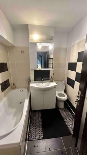 a bathroom with a tub and a sink and a toilet at Georgiana’s central apartment in Buzău