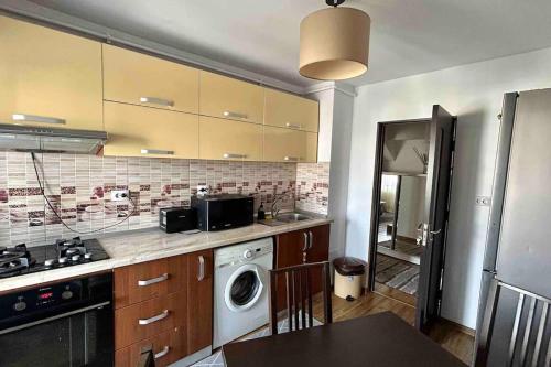 a kitchen with a washing machine and a washer at Georgiana’s central apartment in Buzău
