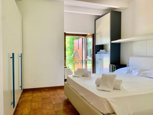 um quarto com uma grande cama branca com almofadas brancas em Turchese Apartment - centrico e con piscina em Sirmione