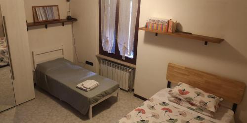 una piccola camera con due letti e una finestra di Casa Romeo a Manerbio