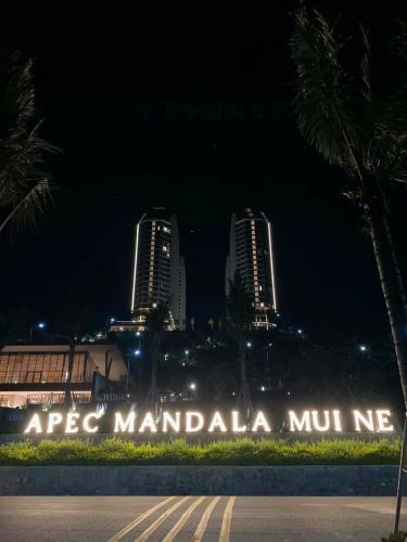 a sign in front of a city at night at Apec Mandala Mũi Né in Ấp Long Sơn