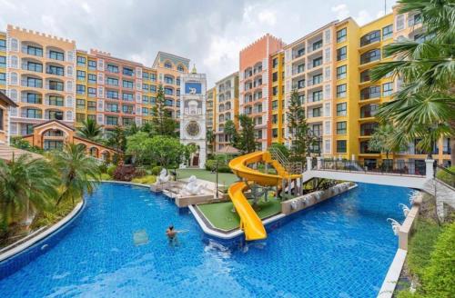 a large pool with a slide in a resort at Venetian Resort Pattaya in Jomtien Beach