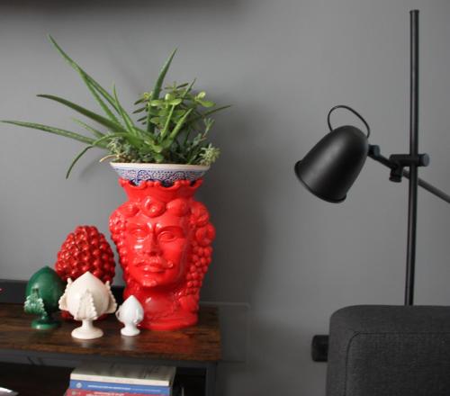 un vaso rosso seduto su un tavolo con una pianta di B&B Le Terrazze Lama Balice - ex B&B SanLorenzo a Bitonto