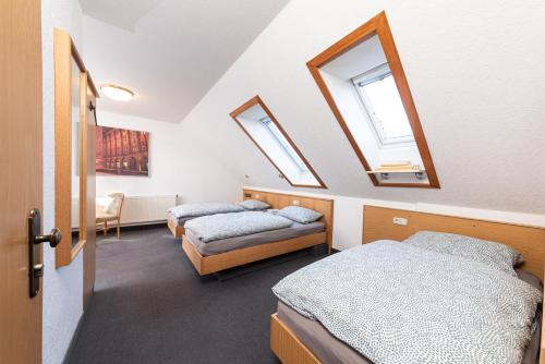 2 camas en una habitación con 2 ventanas en Pension am Sandberg, en Leipzig