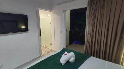 Un dormitorio con una cama con dos toallas blancas encima. en Solar Flats - LaGuNa - Pipa RN, en Pipa