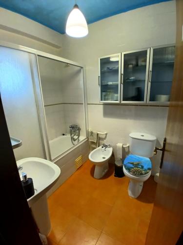 a bathroom with a toilet and a sink and a tub at CASA DIAS in Vila do Bispo