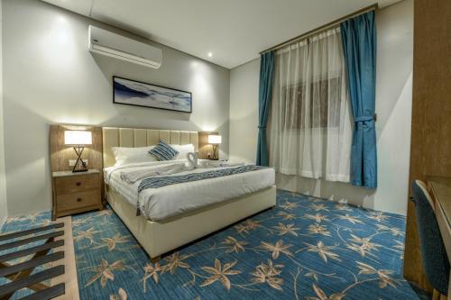 Un dormitorio con una cama grande y alfombra azul. en شقق وغرف امار للشقق المخدومة حي الربيع فئة التصنيف اقتصادي, en Riad