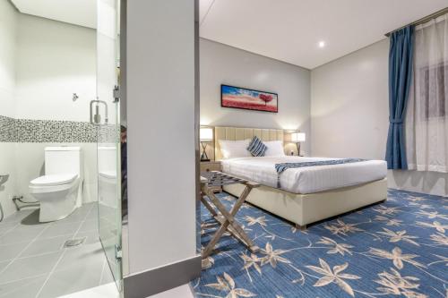 Un dormitorio con una cama tamaño king y un baño. en شقق وغرف امار للشقق المخدومة حي الربيع فئة التصنيف اقتصادي, en Riad