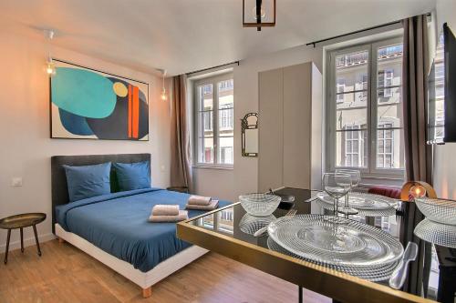 um quarto com uma cama, uma mesa e cadeiras em LES TOITS DU VIEUX-PORT em Marselha
