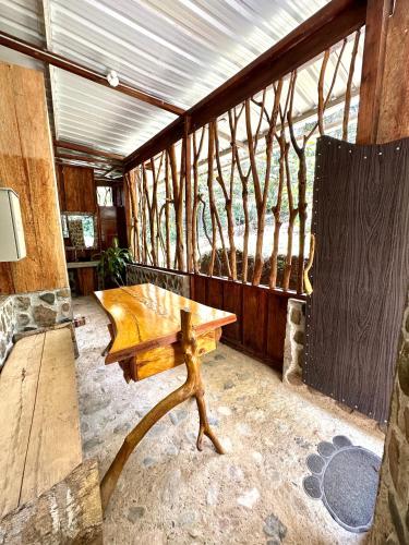 a wooden bench in a room with a table at Huaca Huaca Hostel in Mocoa