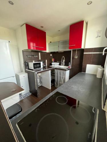a kitchen with red cabinets and a counter top at Apt Chic and Luxury on Collines de Marcel Pagnol Wifi iptv and free parking secure in Marseille