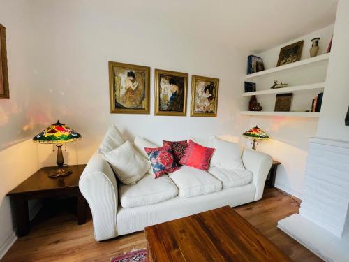 a living room with a white couch and two lamps at Hidden Cottage with Parking in Esher Surrey - Pass the Keys in Esher