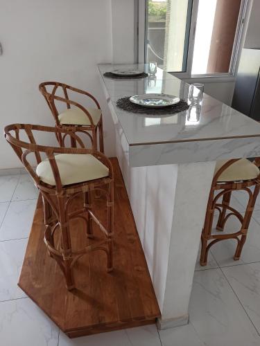 a kitchen with two chairs and a counter top at Chez Fèmi, route des pêches in Cotonou