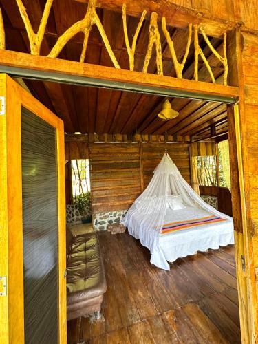 a bed in the inside of a log cabin at Huaca Huaca Hostel in Mocoa