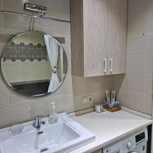 uma casa de banho com um lavatório e um espelho em Однокомнатная квартира студия Мега Парк em Almaty