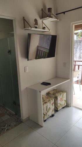 a room with a white desk and a tv on a wall at Solar Flats - WooD - Pipa RN in Pipa