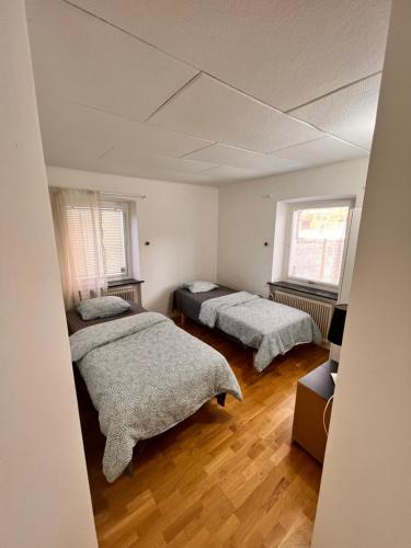 1 dormitorio con 2 camas y 2 ventanas en HBA Appartments en Malmö