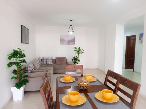 a dining room with a table and chairs and a living room at Amazing Appartement au centre ville en face HILTON & Gare Train de TGV de TANGER in Tangier