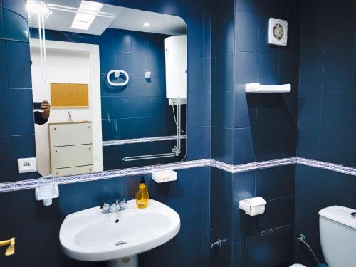 丹吉爾的住宿－Amazing Appartement au centre ville en face HILTON & Gare Train de TGV de TANGER，蓝色的浴室设有水槽和镜子