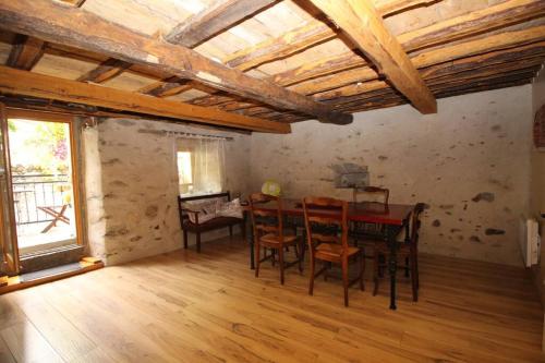 une salle à manger avec une table et des chaises dans une pièce dans l'établissement Chaleureuse maison en pierres avec terrasse, à Auzat