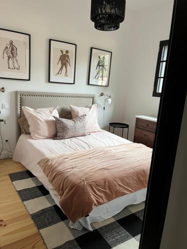 - une chambre avec un lit et des photos sur le mur dans l'établissement Maison des landes st Julien en Born Contis, à Saint-Julien-en-Born