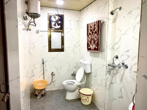 y baño con aseo y lavamanos. en The benaras lounge, en Varanasi