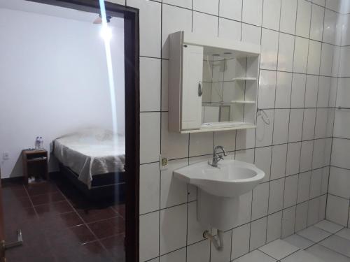 La salle de bains est pourvue d'un lavabo, d'un miroir et d'un lit. dans l'établissement Sitio para lazer, à Bragança Paulista