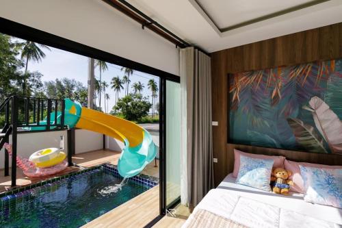 een slaapkamer met een zwembad en een glijbaan bij Sichon Pool Villa - สิชลพูลวิลล่า 