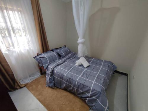 a bedroom with a bed with a blue comforter at consortium apartments in Bungoma