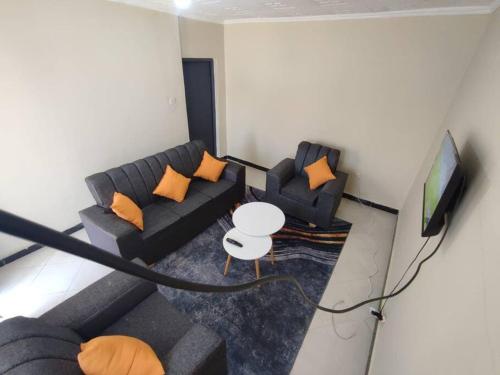 a living room with two couches and a television at consortium apartments in Bungoma