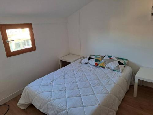 a white bedroom with a bed and a window at 195, studette porte d'Italie rue populaire. in Toulon