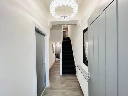 a hallway with a staircase and a chandelier at NEW Spacious 8 Bedroom House Perfect For Groups, Hen, Stag, Football & More! in Liverpool