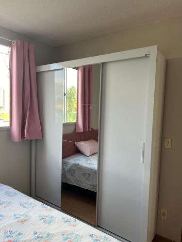 espejo en un dormitorio con cama y ventana en Apartamento ACOMODA 5 PESSOAS próximo ao Uberlândia Shopping en Uberlândia