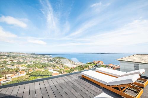 a balcony with a view of the ocean at House of Cork and Ivy - By WeHost in Câmara de Lobos