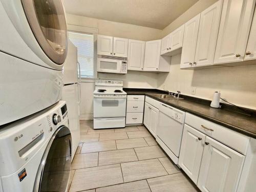 una cocina blanca con electrodomésticos blancos y armarios blancos en Cool and calm place to live, en Memphis