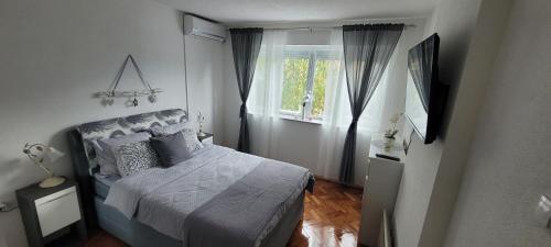 Habitación pequeña con cama y ventana en Apartman Vagon en Brčko