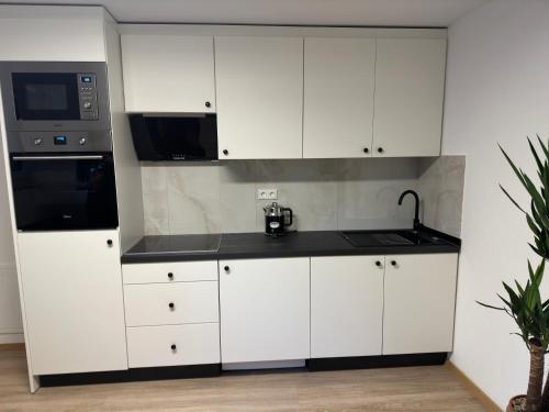 a kitchen with white cabinets and a microwave at Villa Hilden in Hilden