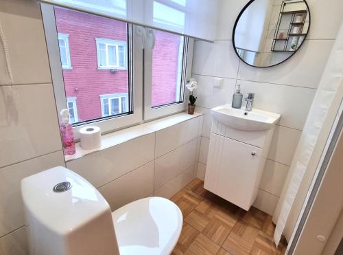 a bathroom with a toilet and a sink and a window at Entire Apartment + 2 Rooms + Self Check-in in Tallinn