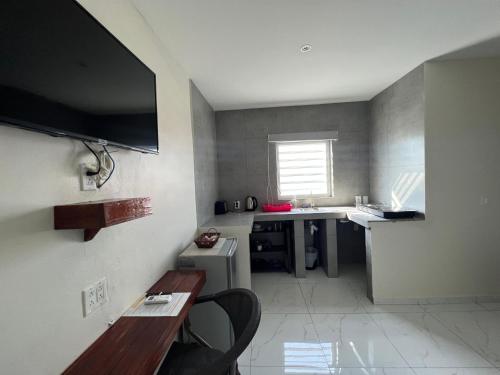 a small kitchen with a table and a desk at Boca Simon Vacation Curacao in Willemstad
