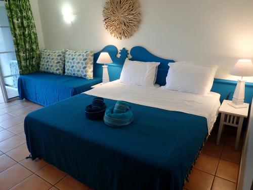 a bedroom with a blue bed and a blue couch at Pierre & Vacances Antigua 03 in Sainte-Luce