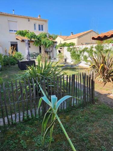 une clôture en bois devant une maison dans l'établissement Charmante maison 6/7 personnes., à Olonne-sur-Mer