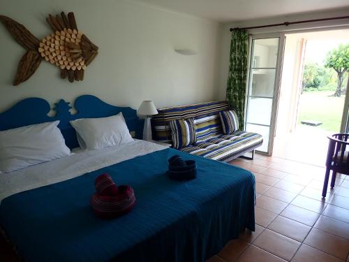 a bedroom with a blue bed with hats on it at Antigua 04 in Sainte-Luce