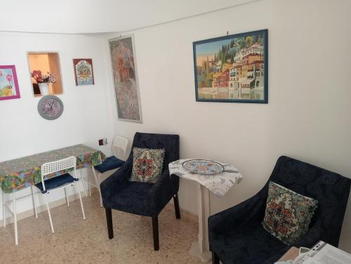 een woonkamer met 2 stoelen en een tafel bij La Casetta in Ostuni