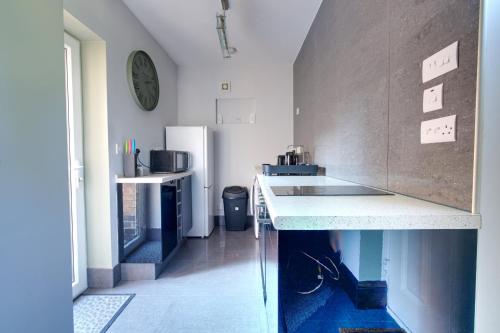 a kitchen with a counter and a refrigerator at #1 Dunkirk by DerBnB, Modern 1 Bedroom City Centre Apartment, Free Parking, WI-FI, Netflix & Within Walking Distance of the City Centre in Derby