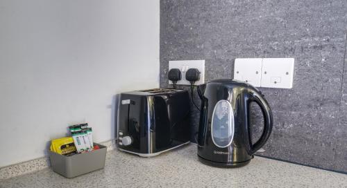 a toaster and a toaster sitting on a counter at #1 Dunkirk by DerBnB, Modern 1 Bedroom City Centre Apartment, Free Parking, WI-FI, Netflix & Within Walking Distance of the City Centre in Derby