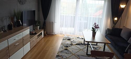 NOVA Apartment في سانوك: غرفة معيشة مع أريكة وطاولة