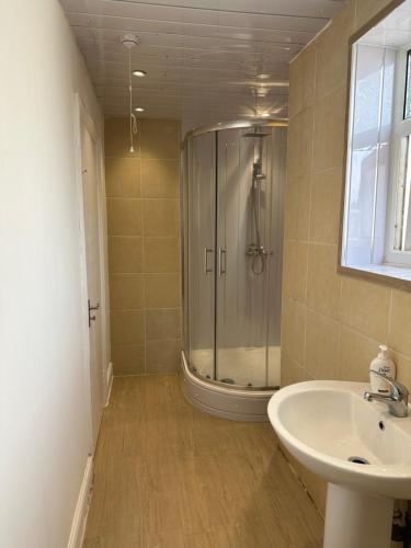 a bathroom with a shower and a sink at Liverpool Street Blue Bedroom in London