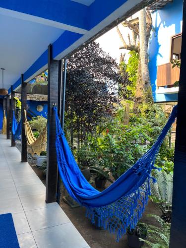 a blue hammock hanging from the side of a building at Pousada dos Meros in Abraão