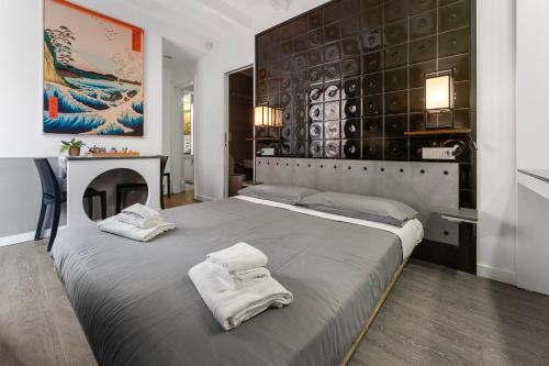 a bedroom with two white towels on a bed at Ukiyo Suites And Rooms in Cagliari
