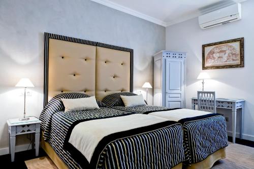 a bedroom with a large bed with a large headboard at Grand Hotel des Terreaux in Lyon